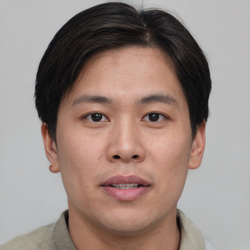 Joyful asian young-adult male with short  brown hair and brown eyes