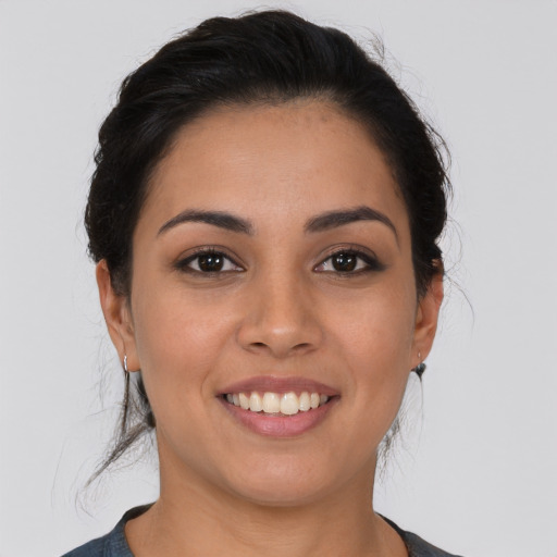 Joyful latino young-adult female with medium  brown hair and brown eyes