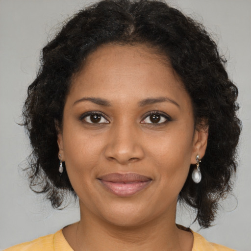 Joyful black young-adult female with medium  brown hair and brown eyes
