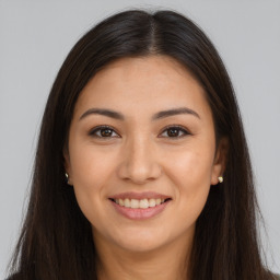 Joyful latino young-adult female with long  brown hair and brown eyes