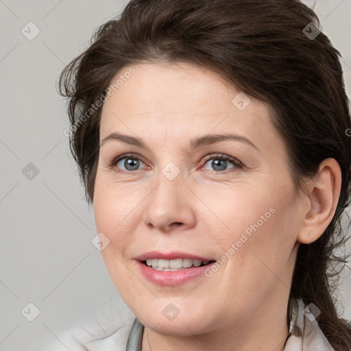 Joyful white adult female with medium  brown hair and grey eyes