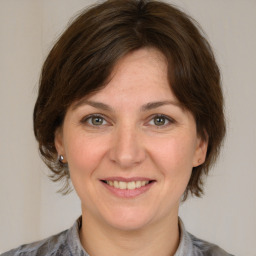 Joyful white adult female with medium  brown hair and brown eyes