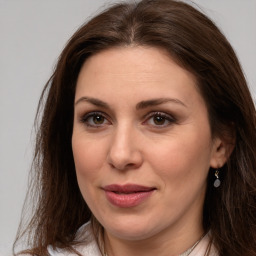 Joyful white adult female with long  brown hair and brown eyes