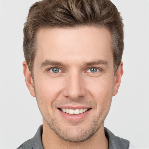 Joyful white young-adult male with short  brown hair and grey eyes