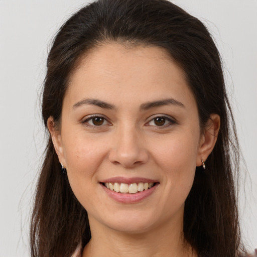 Joyful white young-adult female with long  brown hair and brown eyes