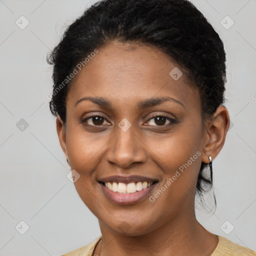 Joyful black young-adult female with short  black hair and brown eyes