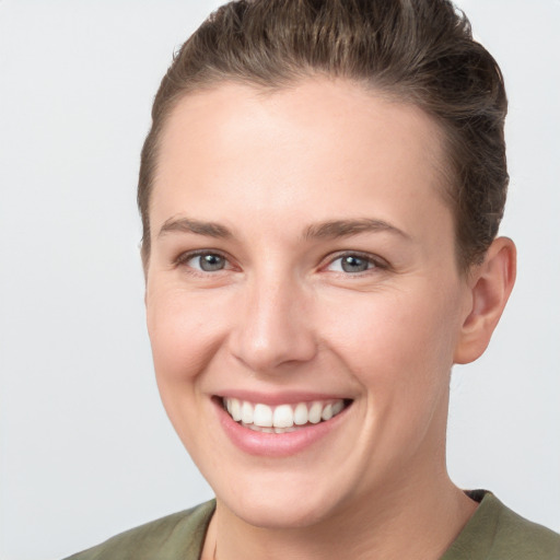 Joyful white young-adult female with short  brown hair and grey eyes