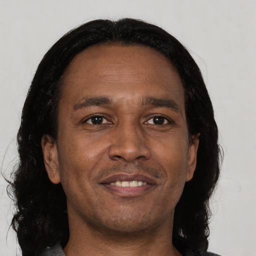 Joyful black adult male with short  brown hair and brown eyes