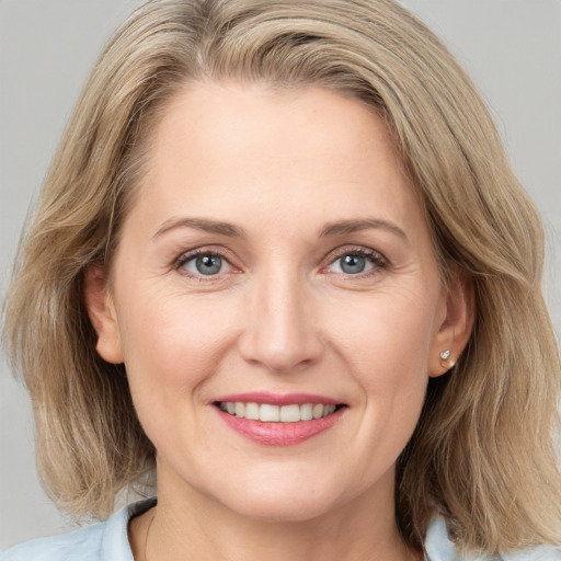 Joyful white adult female with medium  brown hair and grey eyes