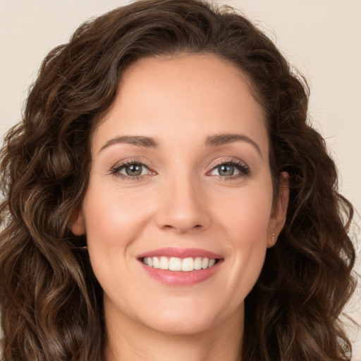 Joyful white young-adult female with long  brown hair and green eyes