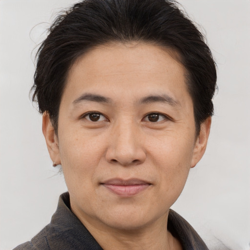 Joyful asian adult male with short  brown hair and brown eyes