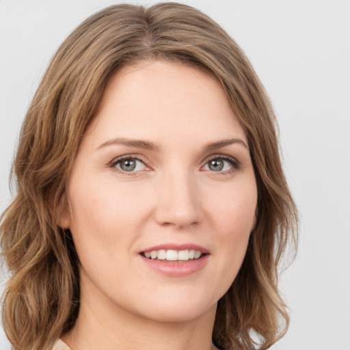 Joyful white young-adult female with medium  brown hair and green eyes