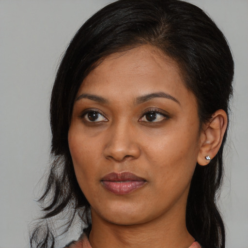 Joyful black young-adult female with long  brown hair and brown eyes