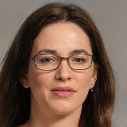 Joyful white adult female with long  brown hair and grey eyes