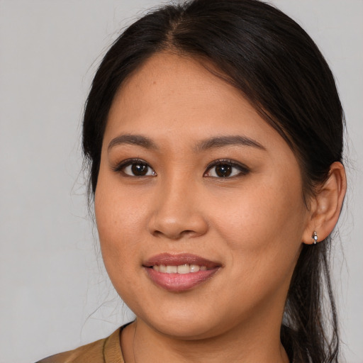 Joyful latino young-adult female with long  brown hair and brown eyes