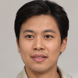 Joyful asian young-adult male with short  brown hair and brown eyes