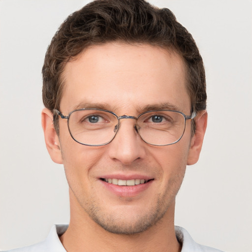 Joyful white young-adult male with short  brown hair and grey eyes