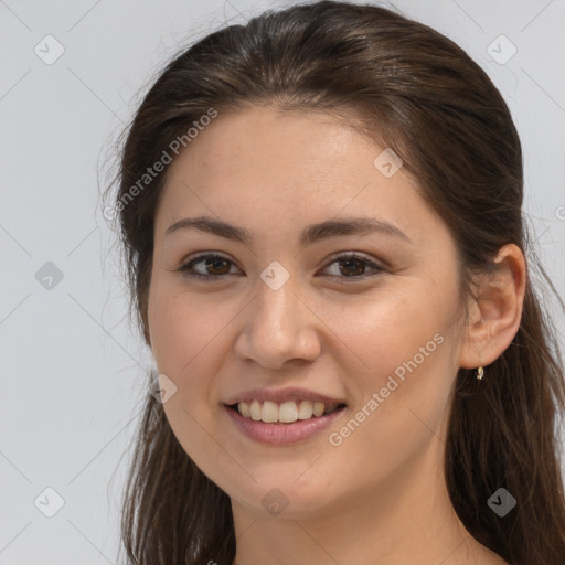 Joyful white young-adult female with long  brown hair and brown eyes