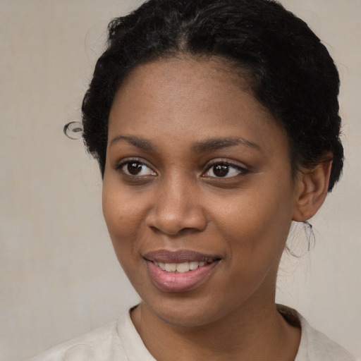 Joyful black young-adult female with short  brown hair and brown eyes