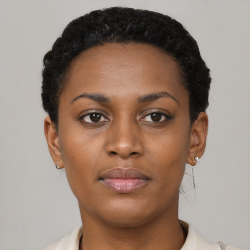 Joyful black young-adult female with short  black hair and brown eyes