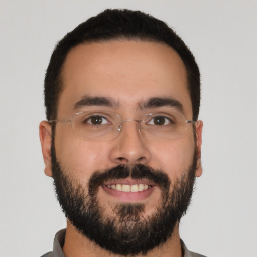 Joyful latino young-adult male with short  black hair and brown eyes