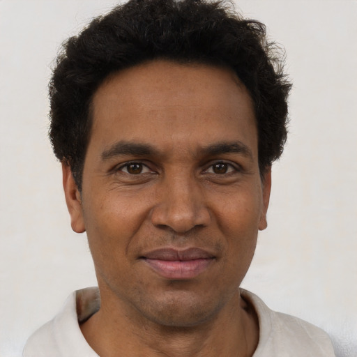 Joyful black adult male with short  black hair and brown eyes