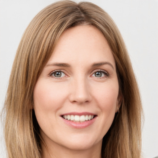 Joyful white young-adult female with long  brown hair and green eyes