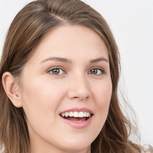 Joyful white young-adult female with long  brown hair and blue eyes