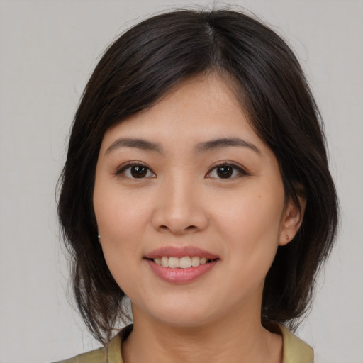 Joyful asian young-adult female with medium  brown hair and brown eyes