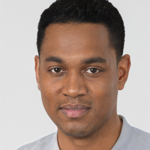 Joyful black young-adult male with short  black hair and brown eyes