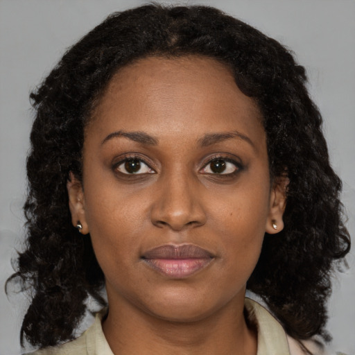 Joyful black adult female with medium  brown hair and brown eyes