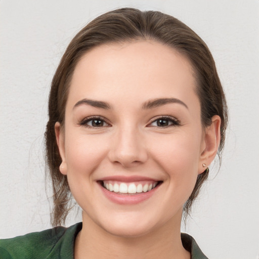 Joyful white young-adult female with medium  brown hair and grey eyes