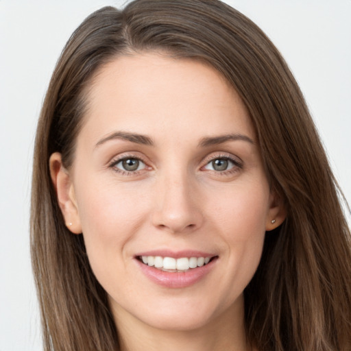 Joyful white young-adult female with long  brown hair and grey eyes