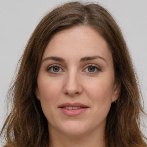 Joyful white adult female with long  brown hair and green eyes