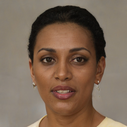 Joyful black adult female with short  brown hair and brown eyes