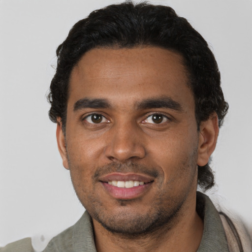 Joyful black young-adult male with short  black hair and brown eyes