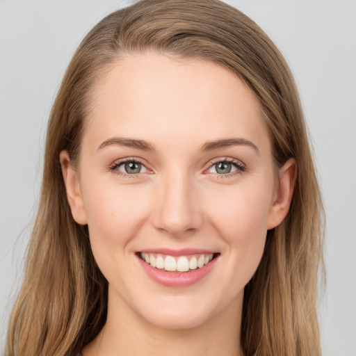 Joyful white young-adult female with long  brown hair and grey eyes