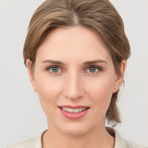 Joyful white young-adult female with medium  brown hair and grey eyes