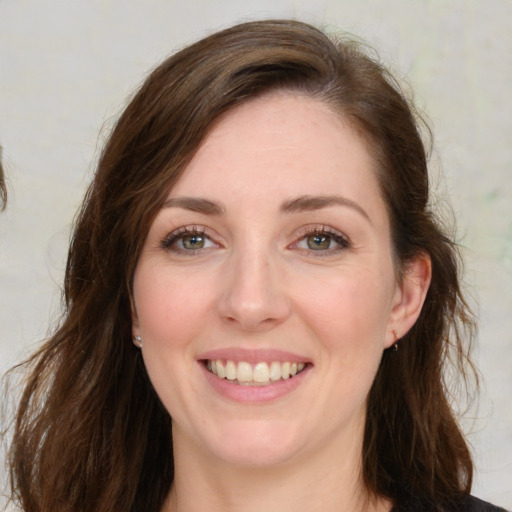 Joyful white young-adult female with medium  brown hair and green eyes