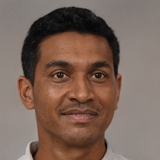 Joyful black adult male with short  black hair and brown eyes