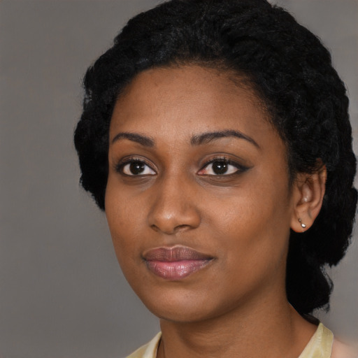 Joyful black young-adult female with short  black hair and brown eyes