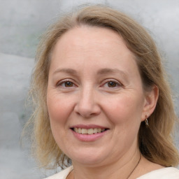 Joyful white adult female with medium  brown hair and blue eyes