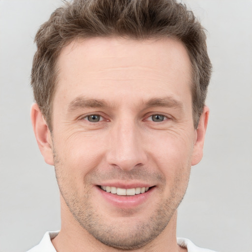 Joyful white adult male with short  brown hair and grey eyes