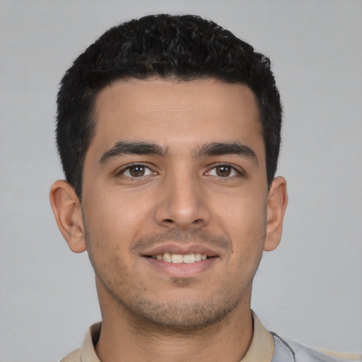 Joyful latino young-adult male with short  black hair and brown eyes
