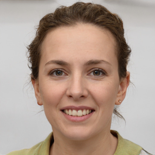 Joyful white young-adult female with medium  brown hair and grey eyes