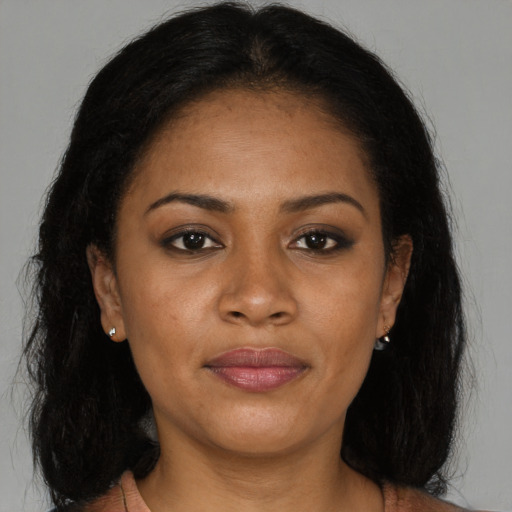Joyful black young-adult female with long  brown hair and brown eyes