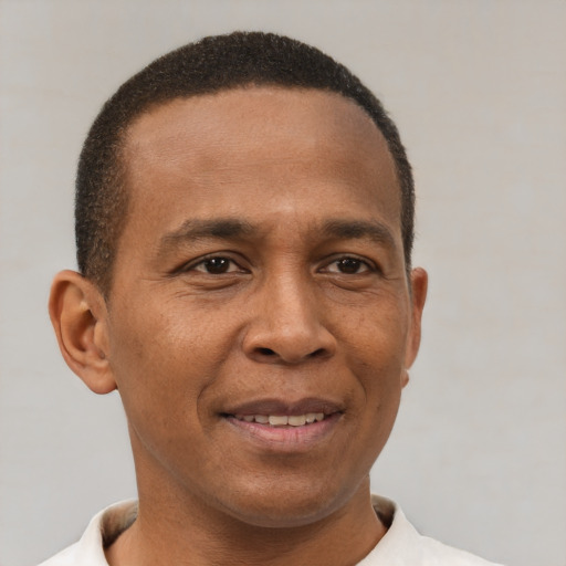 Joyful latino young-adult male with short  brown hair and brown eyes