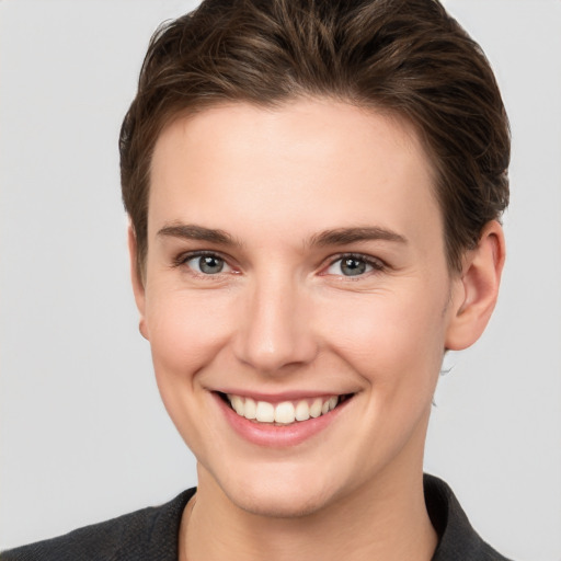 Joyful white young-adult female with short  brown hair and grey eyes