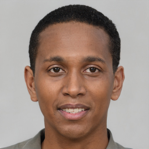 Joyful black young-adult male with short  black hair and brown eyes