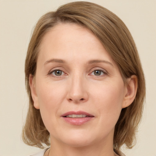 Joyful white adult female with medium  brown hair and grey eyes